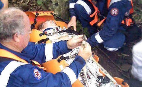The man is loaded into a stretcher. The man is loaded into a stretcher.